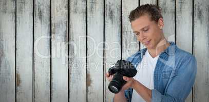 Composite image of male photographer looking at digital camera