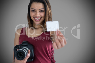 Composite image of portrait of happy woman showing identity card while holding camera