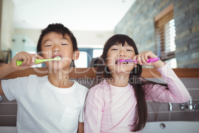 Siblings brushing teeth in the bathroom