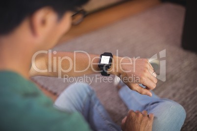 Man using smart watch in living room