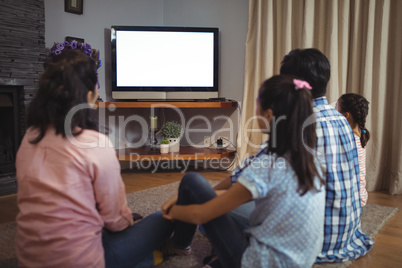 Family watching television together in living room