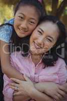 Mother and daughter relaxing on couch outside home