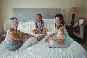 Happy family sitting on bed in bed room