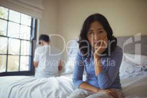 Couple ignoring each other in bedroom