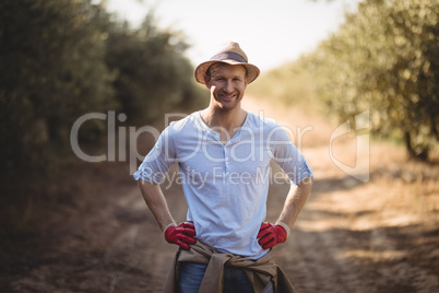 Smiling young man standing on dirt road at farm