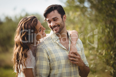 Smiling young couple looking at each other at farm