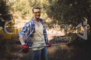 Smiling man holding rake at olive farm