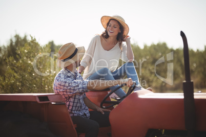 Happy young couple sitting together on tractor