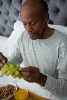 High angle view of senior man having breakfast on bed