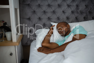 Senior man sleeping on bed at home