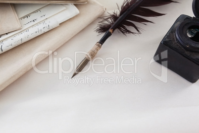 Quill feather, ink bottle and legal documents arranged on white background