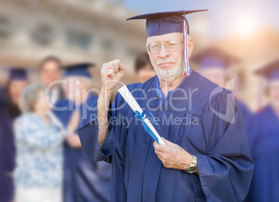 Proud Senior Adult Man In Cap and Gown At Outdoor Graduation Cer