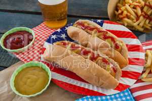 Hot dog served on plate with french fries and sauce