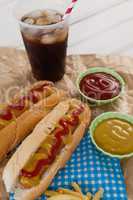 Hot dog, sauces and cold drink on brown paper