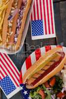 Hot dog and American flag on wooden table