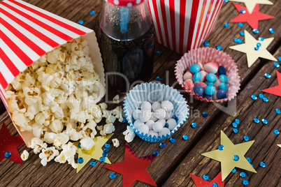 Scattered popcorn and sweet food decorated with 4th july theme