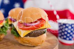 American flag and burgers on wooden table