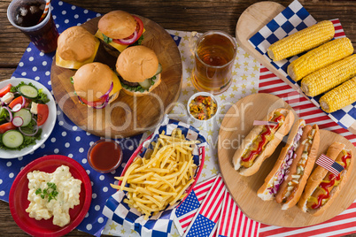 Hot dogs and burgers on wooden table with 4th july theme