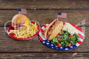 Burger and hot dog on wooden table with 4th july theme