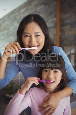 Mother and daughter brushing teeth in the bathroom
