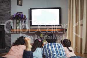 Family watching television together in living room