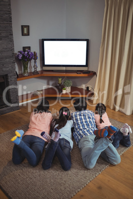 Family watching television together in living room