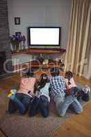 Family watching television together in living room