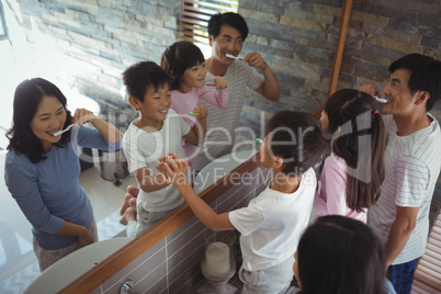 Family brushing teeth together in the bathroom