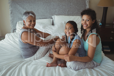 Happy family sitting on bed in bed room