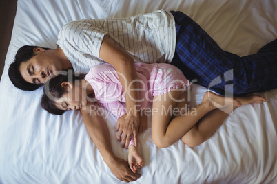 Father and daughter sleeping together in bedroom