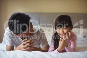 Father and daughter lying together in bedroom