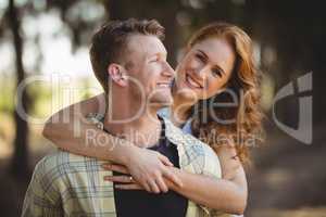 Smiling woman embracing man at olive farm