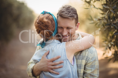 Happy young couple embracing at olive farm