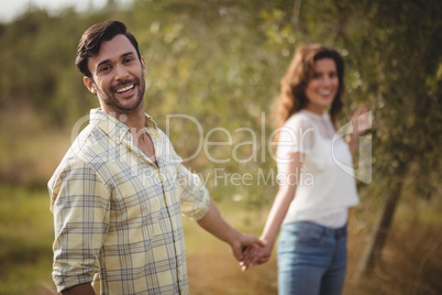 Handsome young man holding woman at olive farm