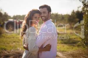 Portrait of smiling young couple embracing at olive farm