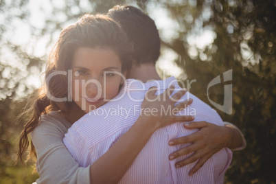 Portrait of young woman hugging boyfriend