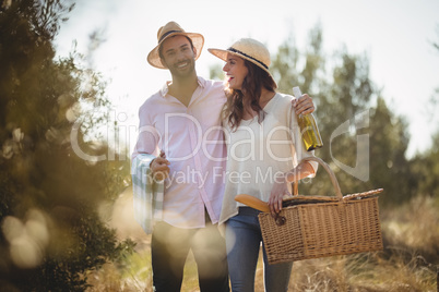 Cheerful couple carrying picnic basket