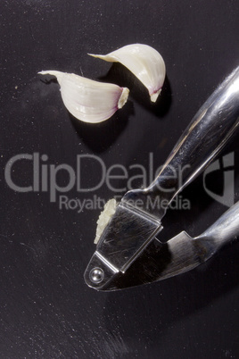 Garlic press and cloves of garlic