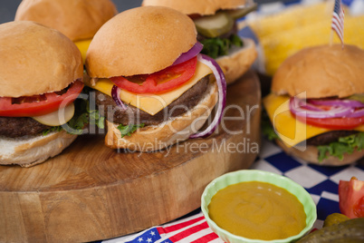 Hamburger with mustard sauce on wooden board