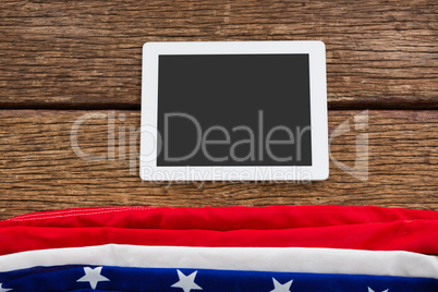 American flag and digital tablet arranged on wooden table