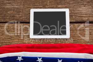 American flag and digital tablet arranged on wooden table