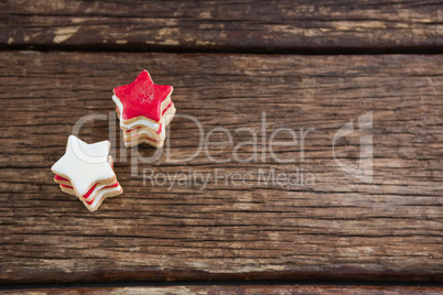 Red and white sugar cookies stacked on wooden table