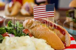 American flag and hot dogs on wooden table