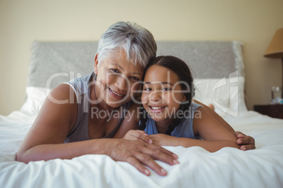 Grandmother and granddaughter relaxing on bed in bed room