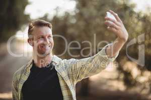 Smiling man taking selfie at olive farm