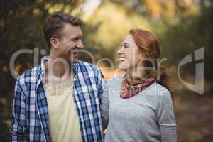 Cheerful couple looking at each other at olive farm