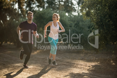 Young couple running during sunny day at farm