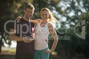 Smiling young couple with mobile phone on sunny day