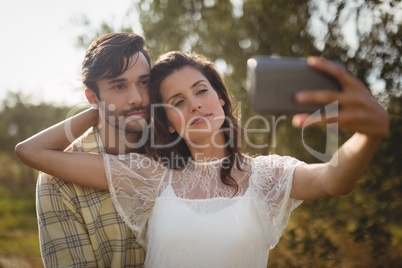 Beautiful young woman taking selfie with man
