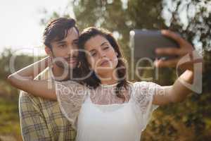 Beautiful young woman taking selfie with man